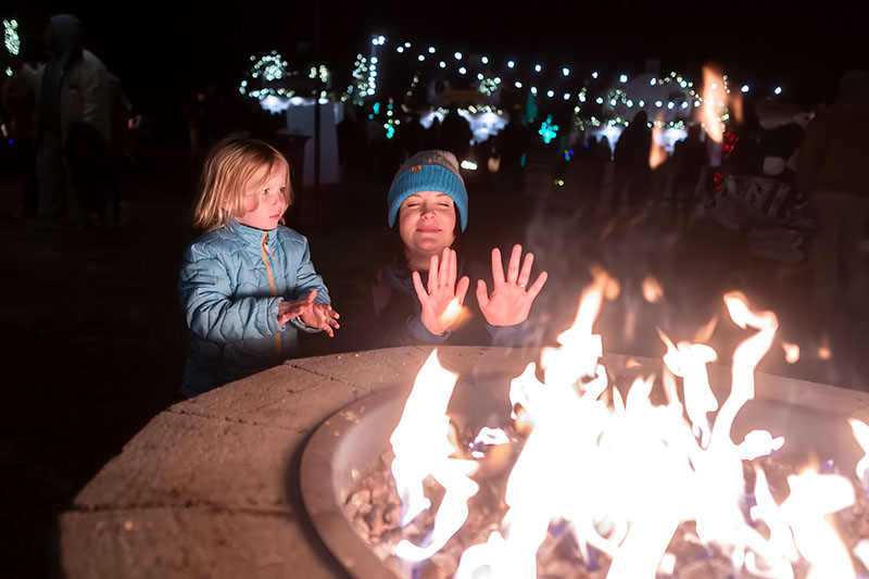 Mother and daughter warming their hands at a fire pit